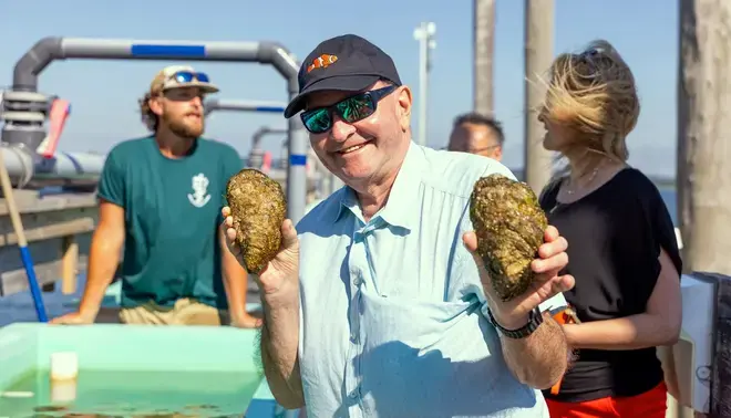 President Miaoulis at CEED event on the dock with giant oysters