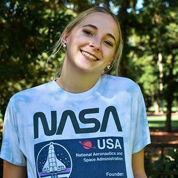 RWU graduate Abigail Clermont smiles wearing a NASA t-shirt