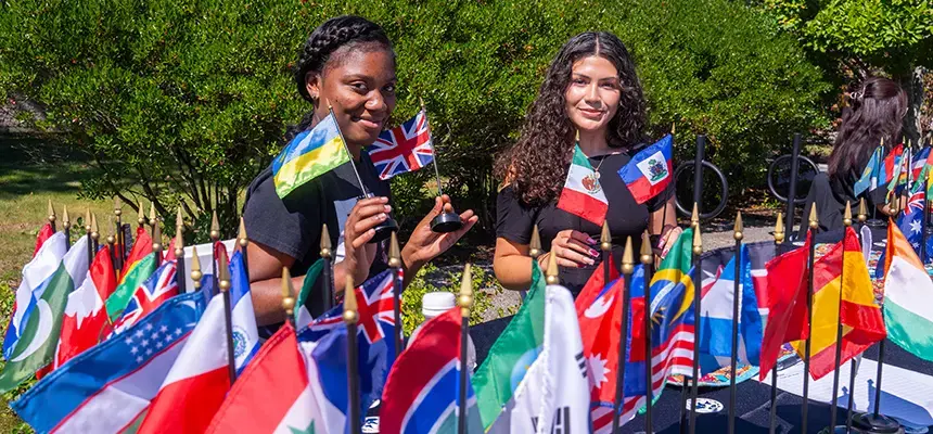 Students pose with flags of many nations