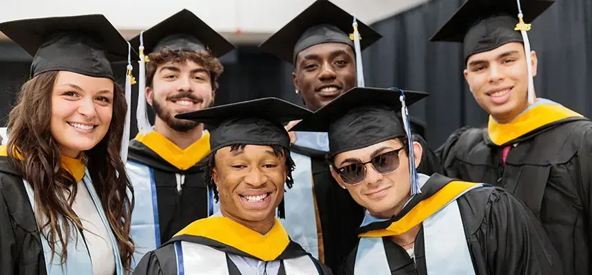 A group of smiling graduates at commencement