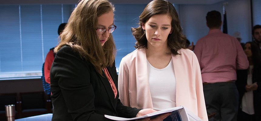 Two students review a report. 