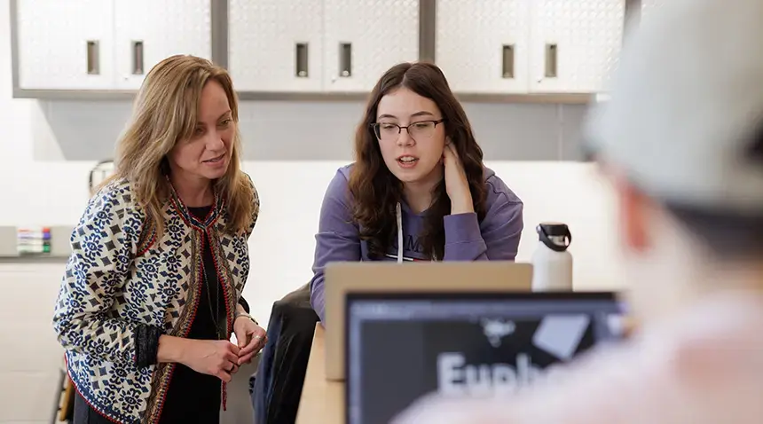 Faculty member and student look at computer screen