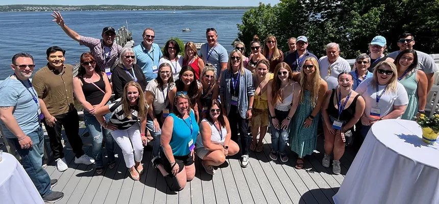 A group of alumni outdoors in front of the bay