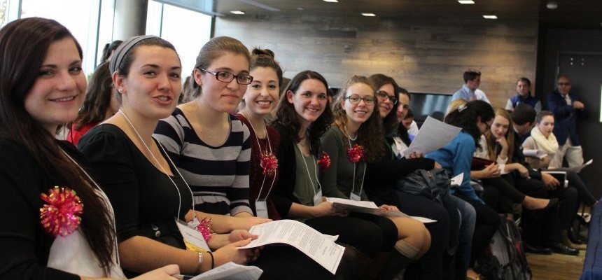 Students sit in a long row at the colloquium