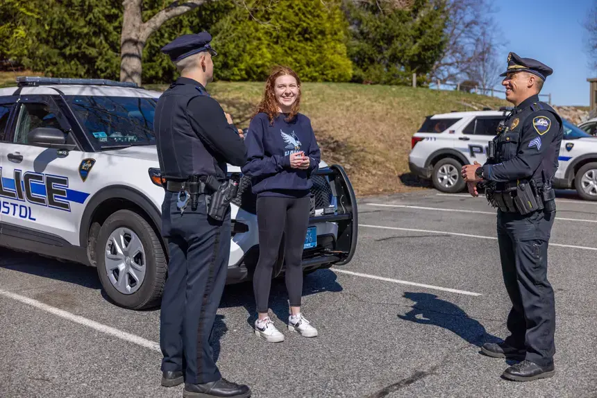 Student speaking with two police officers next to police vehicle