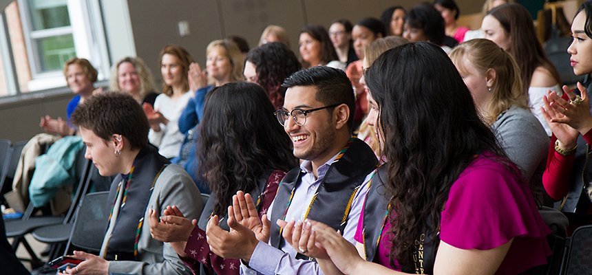 image of young diverse RWU alumni applauding at an event on the Bristol campus