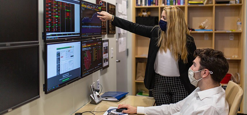 Students point to computer display of financial data