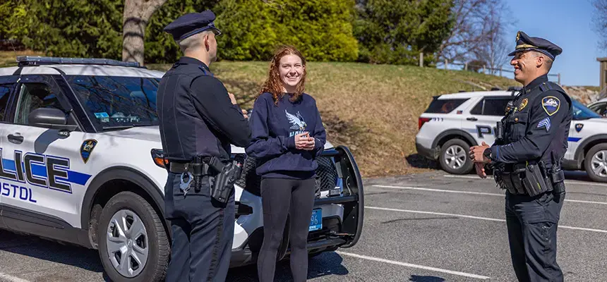 Student speaking with two police officers next to police vehicle