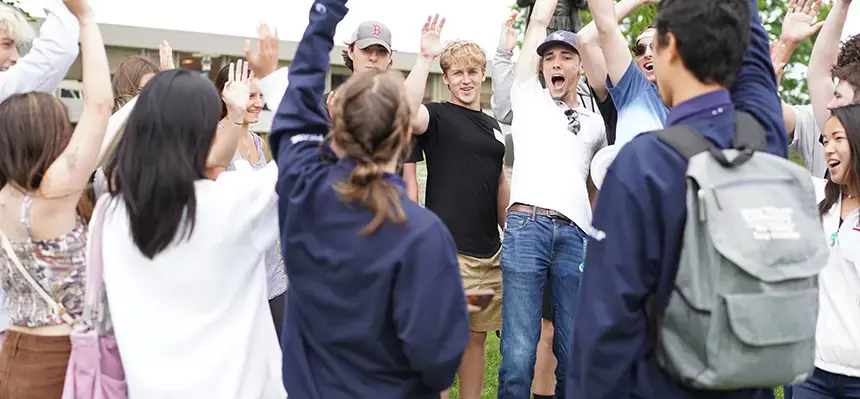 Students cheer near the Roger Williams statue on campus