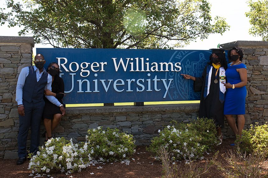 Image of a family posing with the Roger Williams University Sign