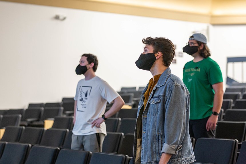 Image of members of Hawkward a capella singing group at practice wearing a mask made especially for singing