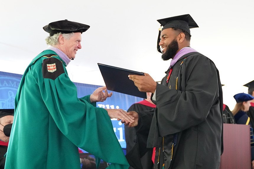 Graduate receives diploma from Dean