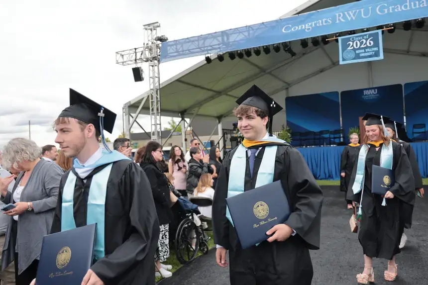 Graduates depart the Commencement main ceremony with diploma in hand.