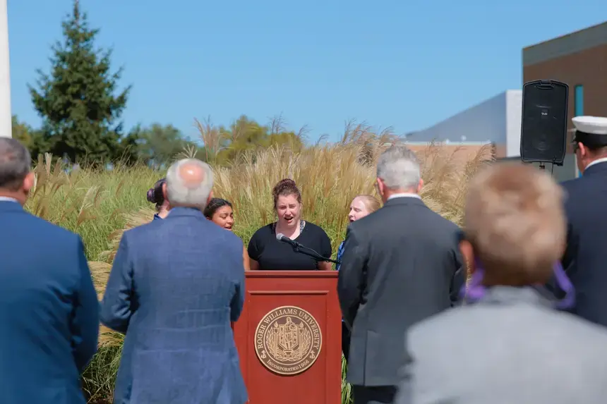 The ceremony opened with the national anthem performed by Drastic Measures before speakers offered reflections spanning generations.