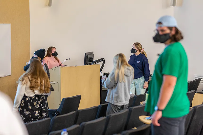 Image of Ava Wilkins with other members of Hawkward a capella singing group at practice wearing a mask made especially for singing