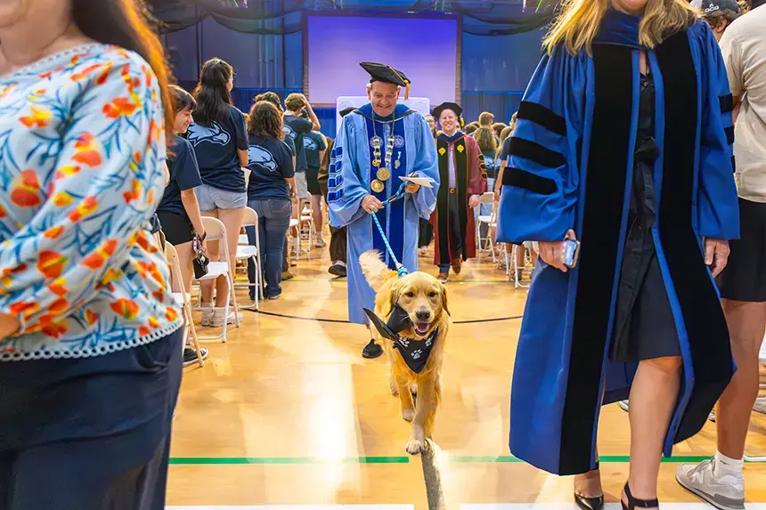 President Yannis leads out faculty members and the Class of 2029 along with First Dog Roger.