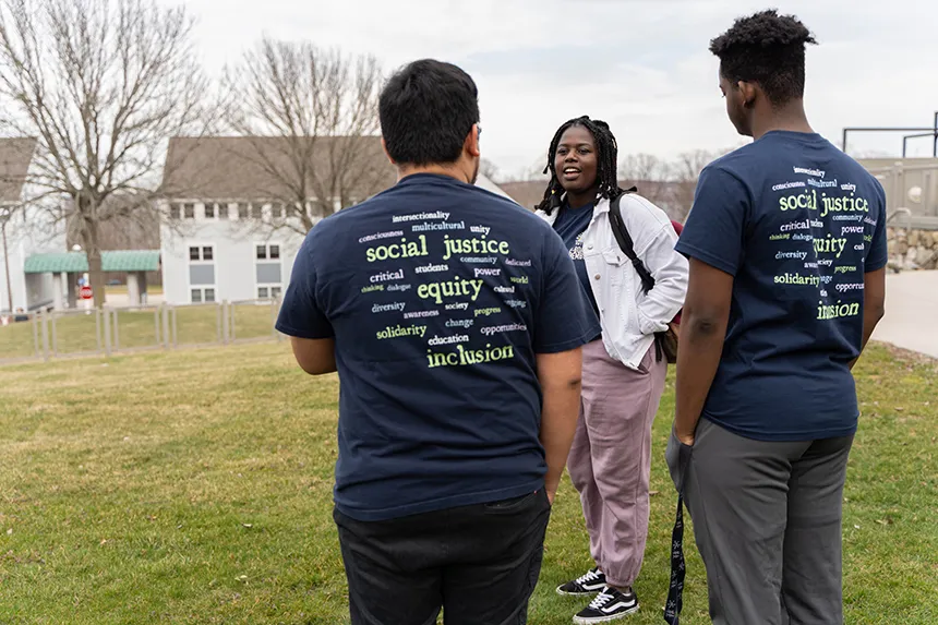 Three MSU e-board members stand outside, talking. 