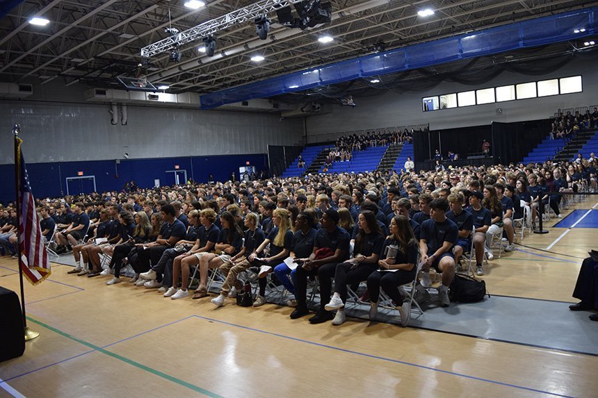 A wide shot of all the RWU incoming students sitting on chairs in the fieldhouse