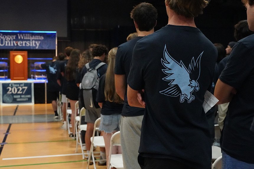 The back of a student's navy blue t-shirt with a light blue Hawk 