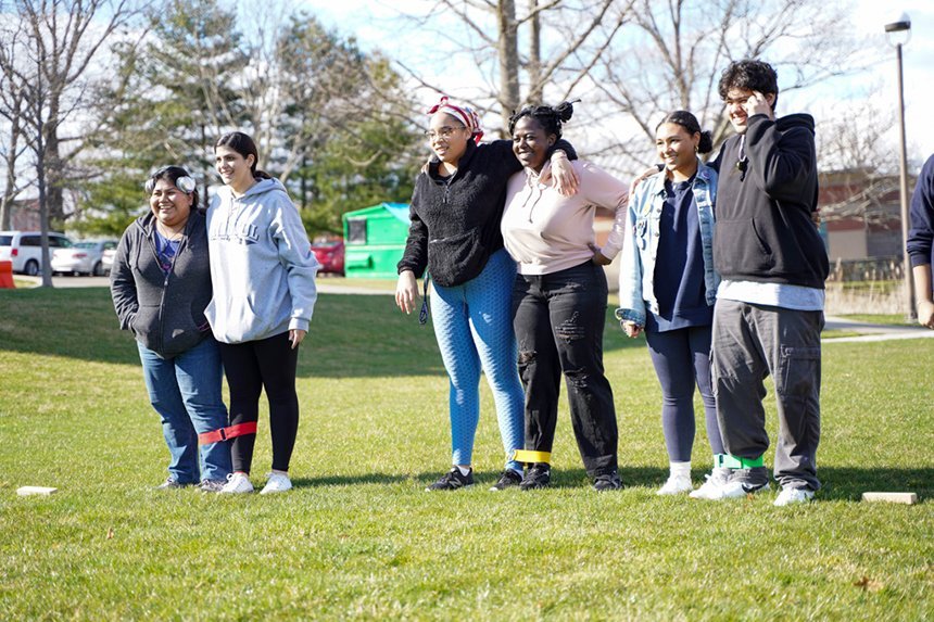 Three groups of students get ready for a three-legged race. 