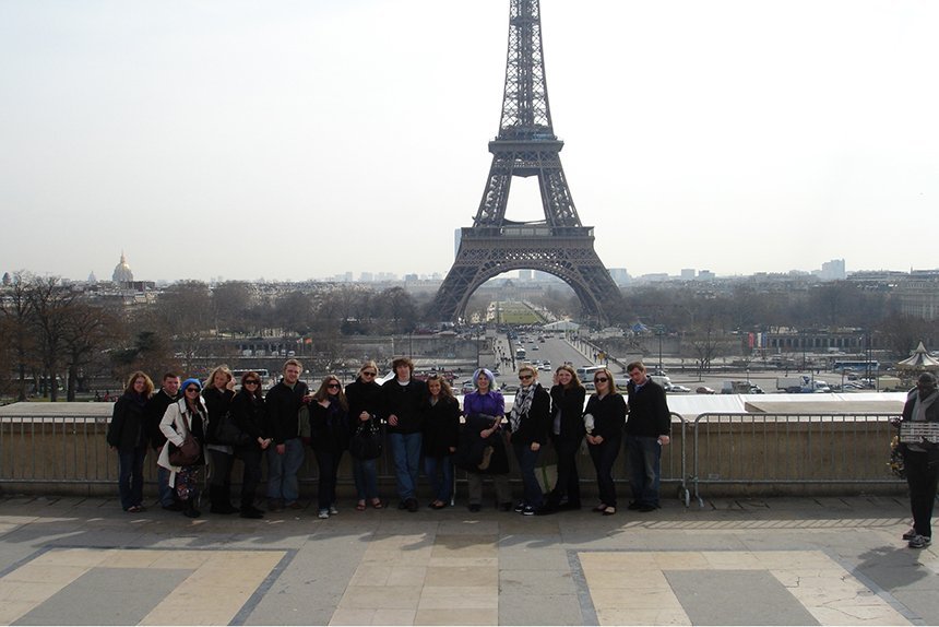 A group of students stand in front of the Eiffel Tower