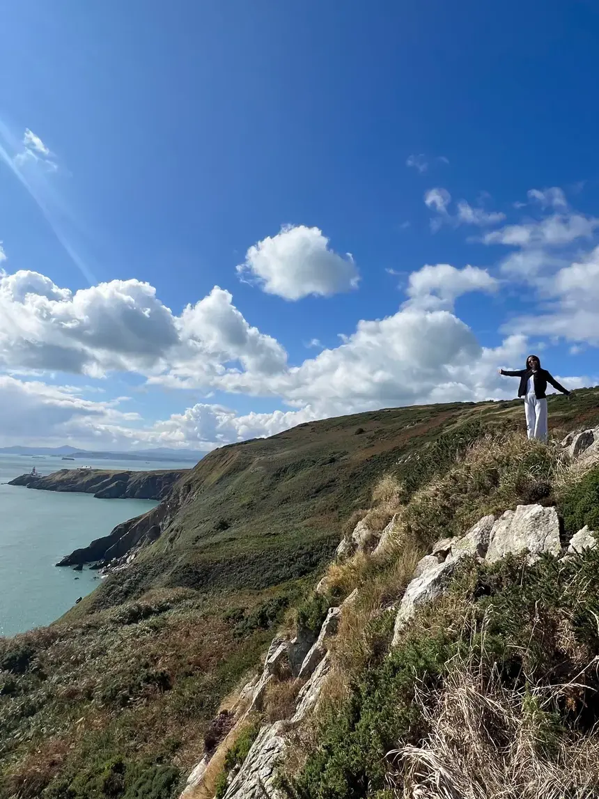 A portrait of a female student standing on seaside cliff