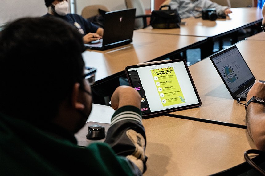 An MSU e-board member looks at flyer designs on an iPad for Stay Woke Week.
