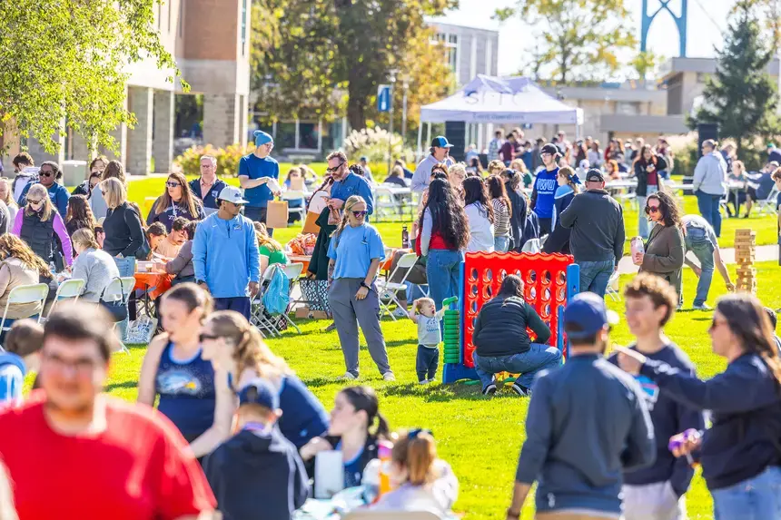 Homecoming and Family Weekend attendees engage on the Commons Quad.