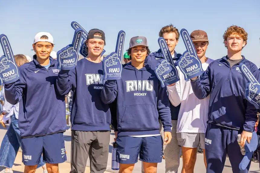 Student-athletes pose with foam fingers.