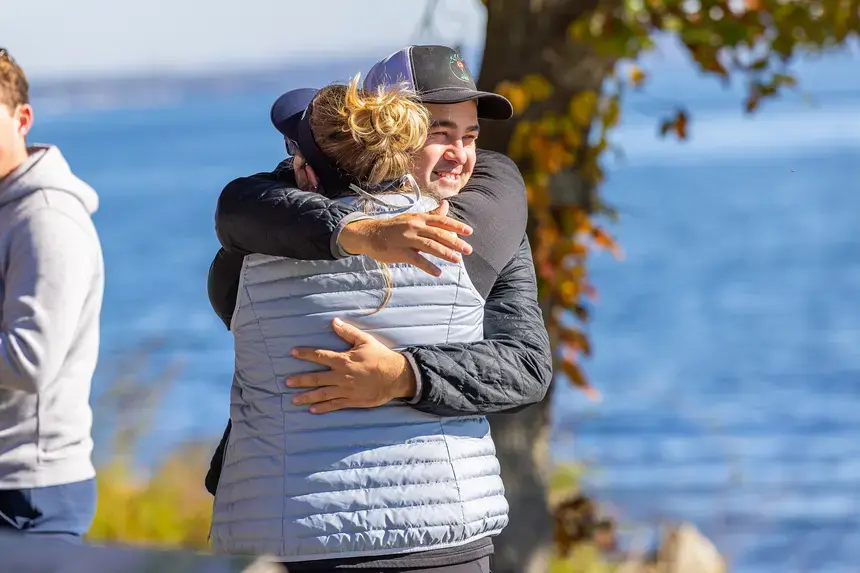 Homecoming and Family Weekend attendees hug.