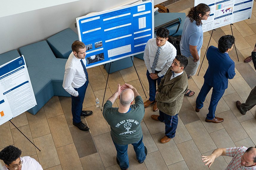 A photo looking down at a group standing around a poster. 