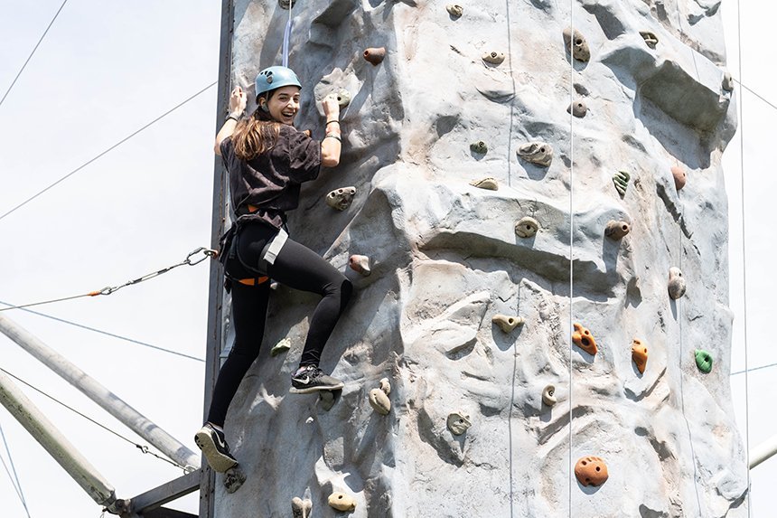A student climbs the rock-climbing wall. 
