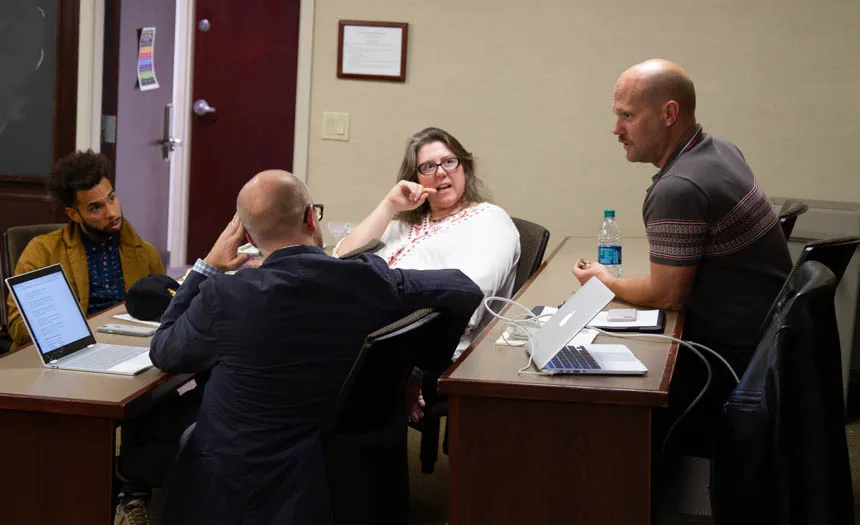 Four faculty members have a discussion. 
