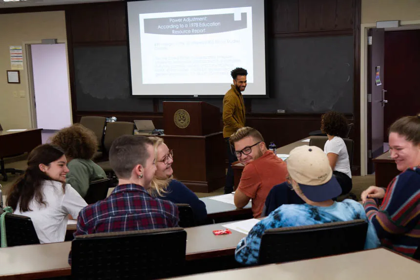 Peers smile at a fellow student in the classroom.
