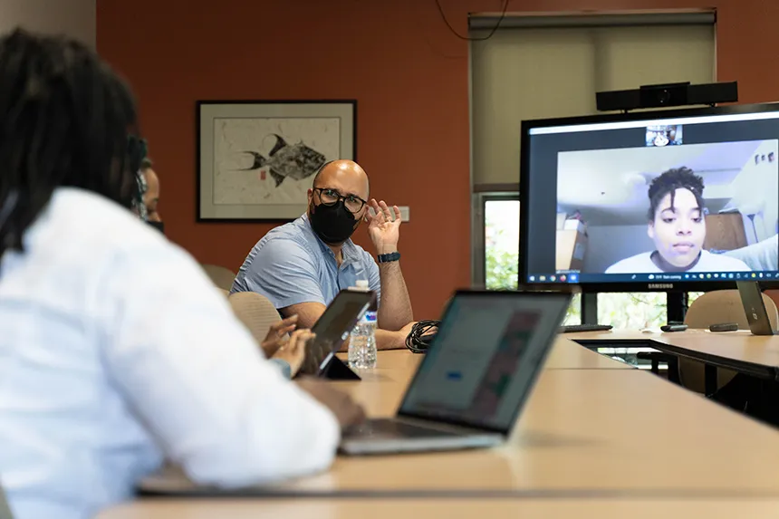 Members of MSU's e-board meet in a classroom, as one student Zooms in. 