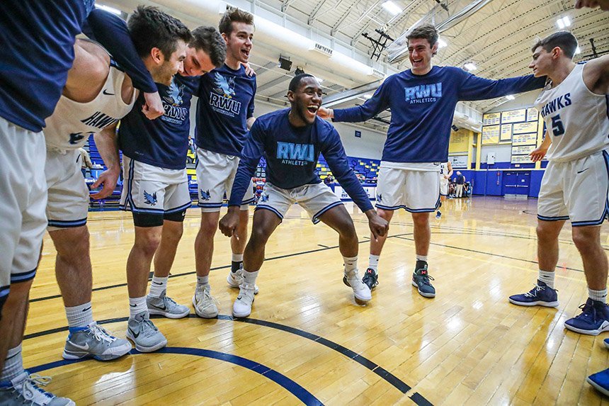 image of RWU student athletes in a huddle on the court