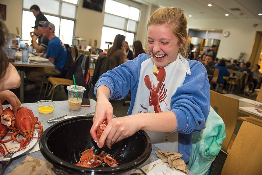 image of a student enjoying a lobster dinner in Upper Commons. Niche recently ranked RWU No. 1 for best college food in Rhode Island and 23rd nationally.