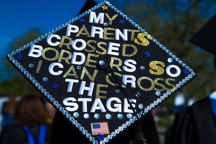 image of mortarboard: 'My parents crossed borders so I can cross the stage'