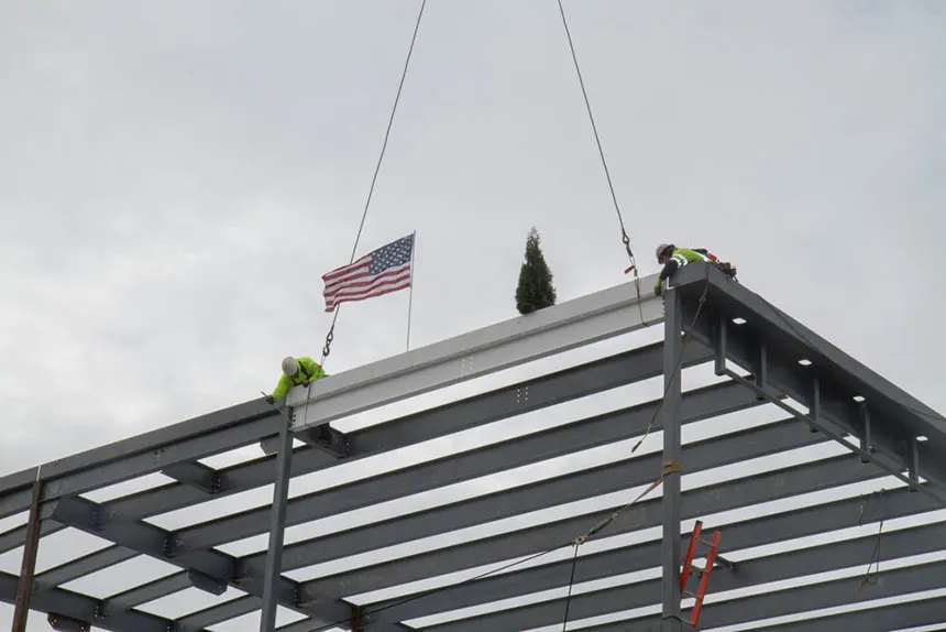 Construction crews bolt the beam into place.