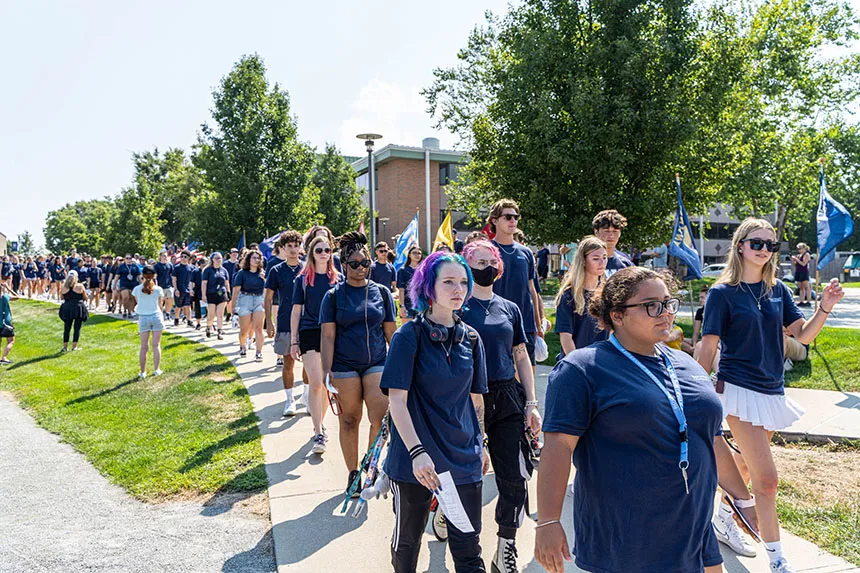 Students process to the Convocation ceremony on the athletic field.