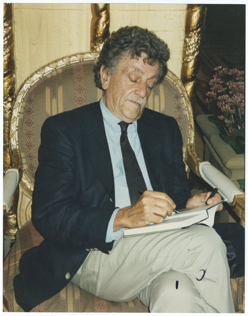 Photograph of Kurt Vonnegut signing a book