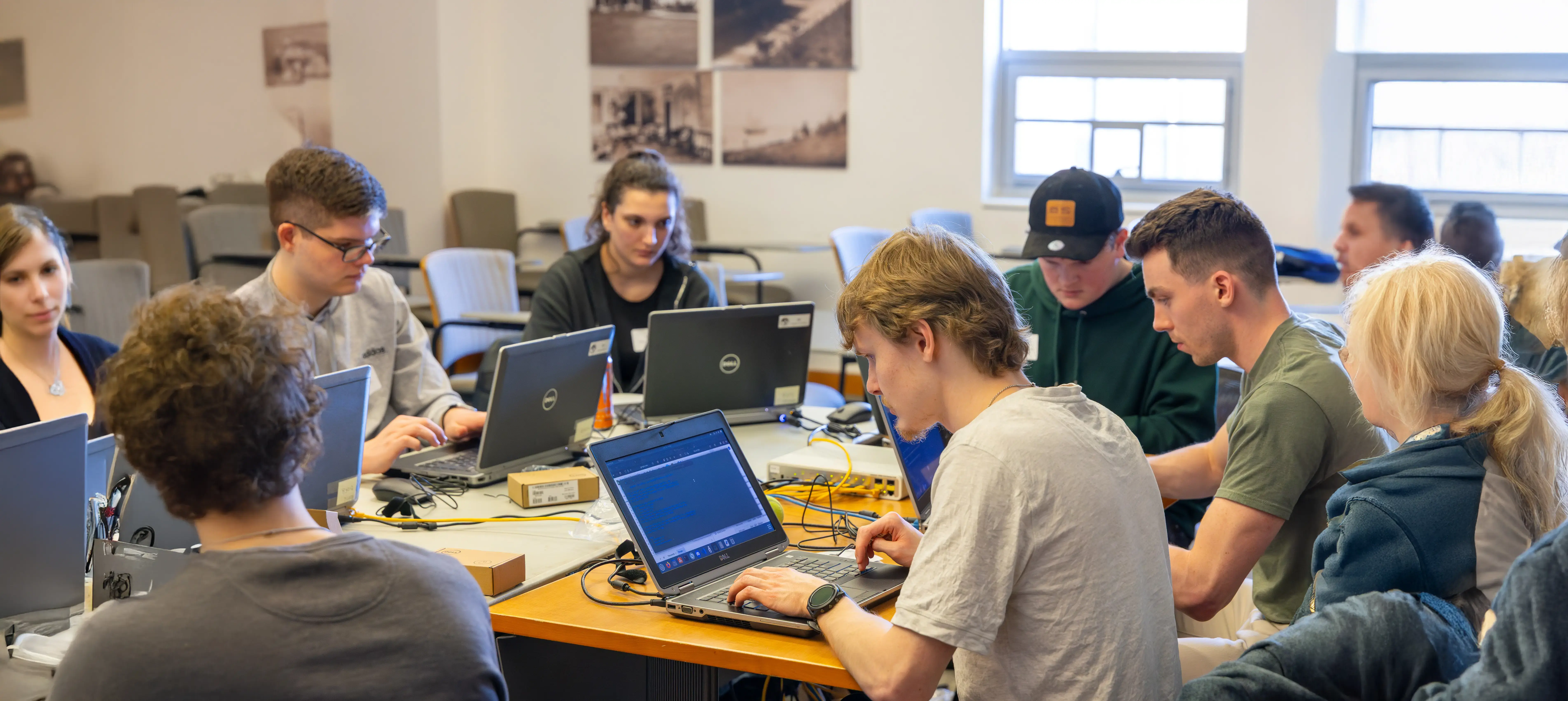 Digital forensics students work on laptops, battling a simulated computer virus launched on a network during an exercise.