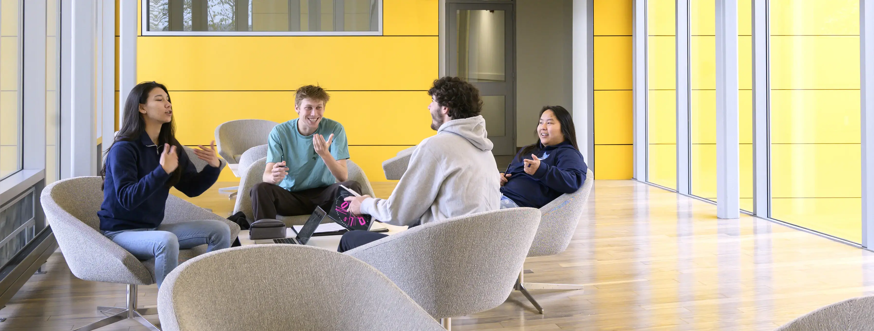 Students discuss English Lit in a bright seating area