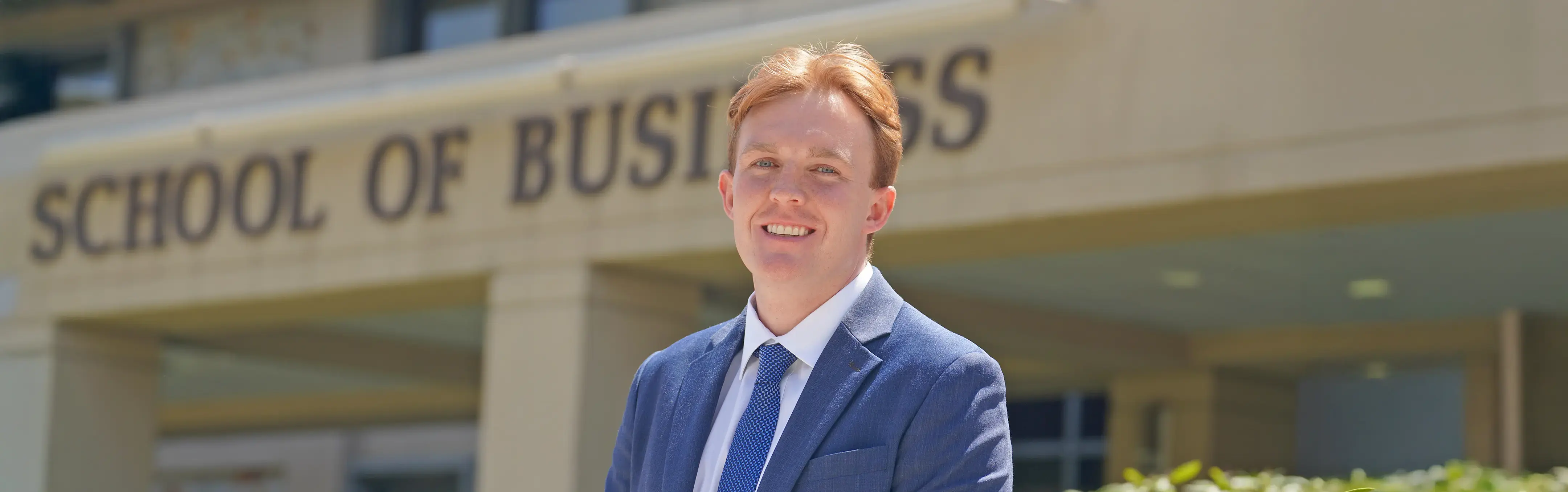 A MBA student poses outside the business school