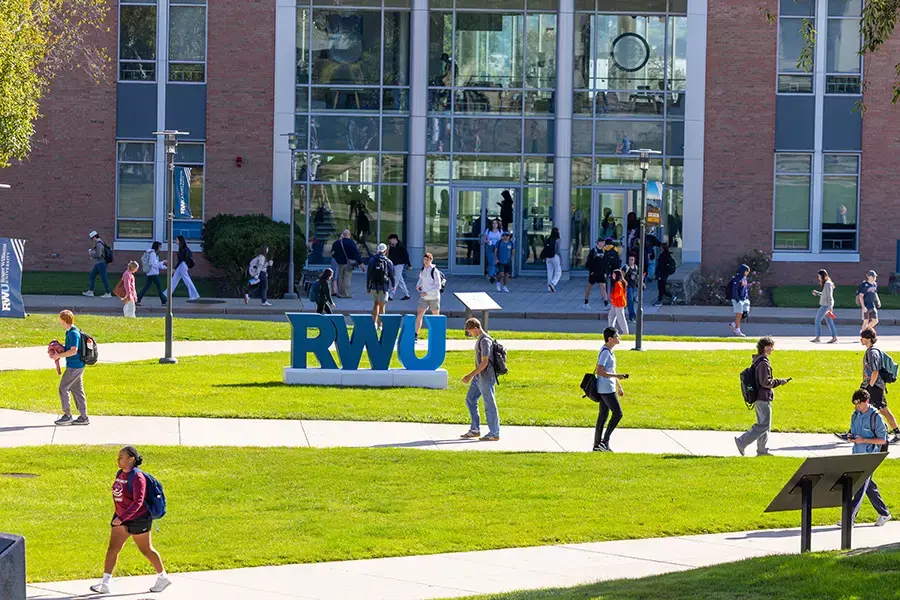 Students walk past RWU sign on campus