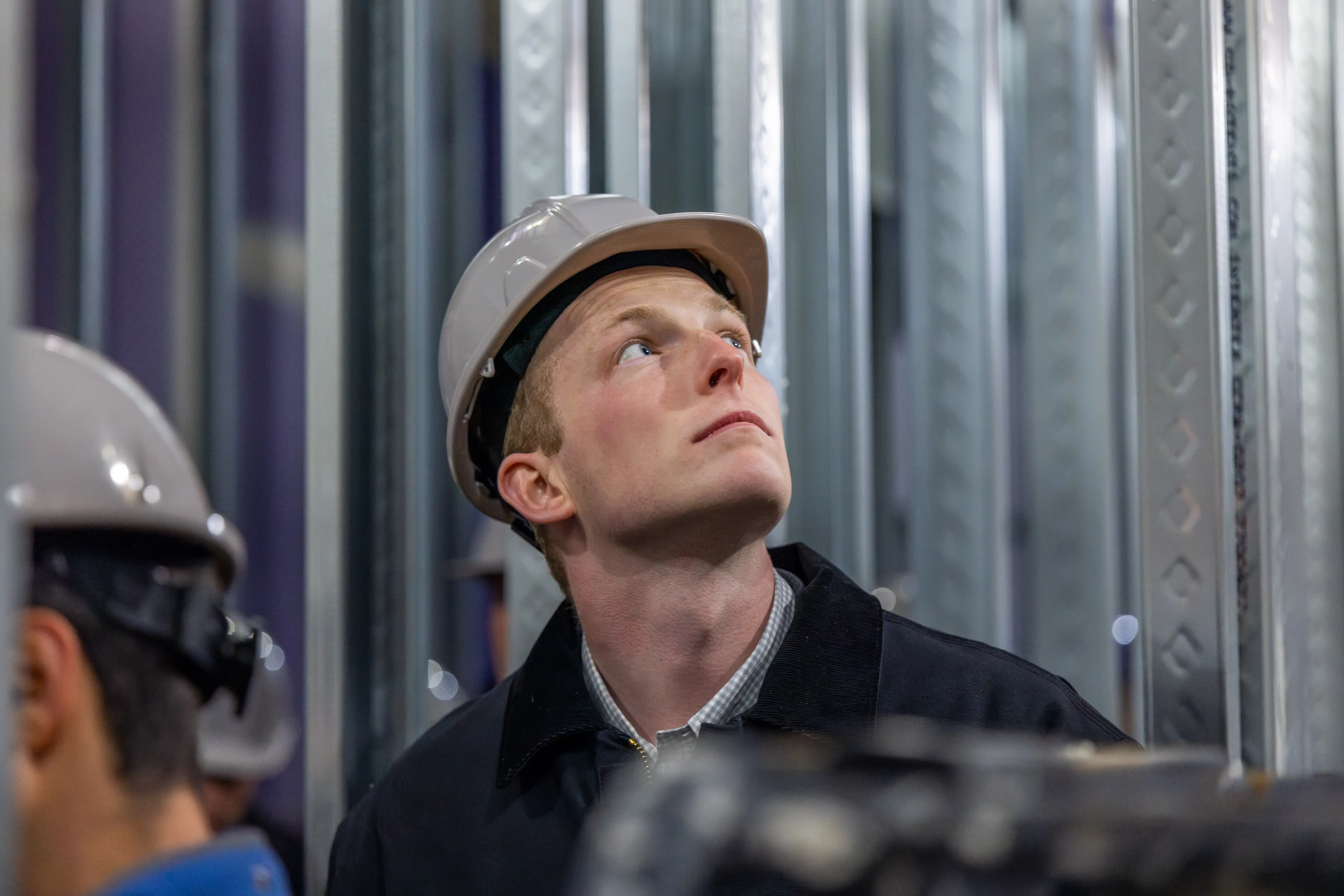Man wearing hard protective hat looking up