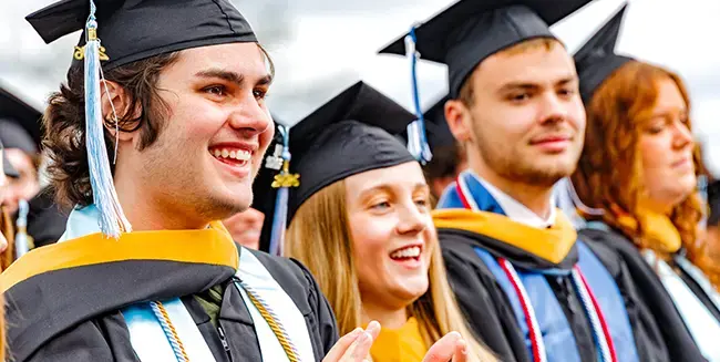 Graduates cheering at commencement