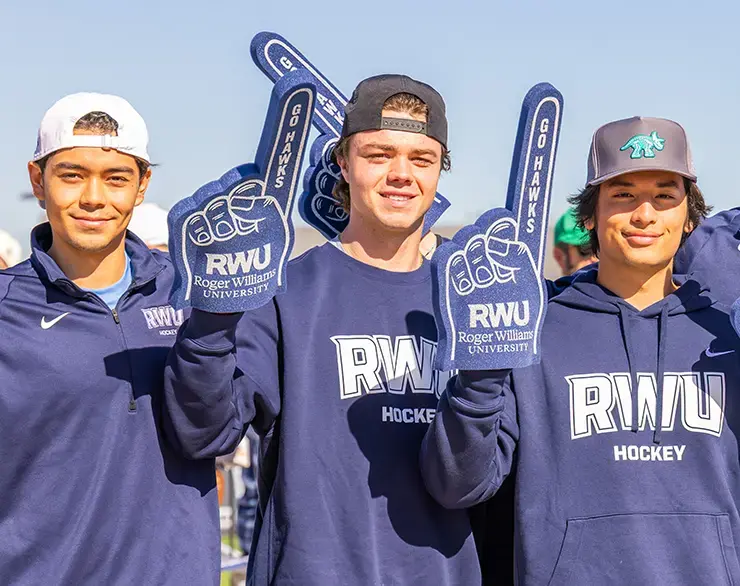 Students hold RWU foam fingers at an athletic game