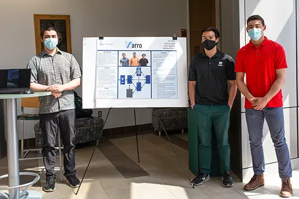 Three Computer Science students stand next to their poster at SASH 