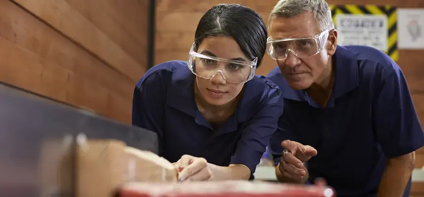 instructor and student wearing safety glasses working in carpentry class